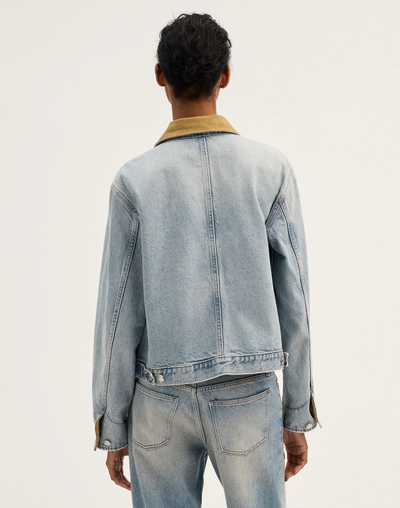 Light blue denim jacket with tan contrast trim styled for casual wear